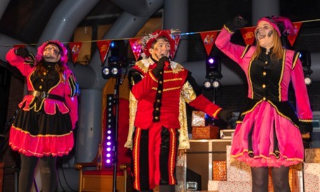 Pieten voeren een vrolijk optreden uit op het podium tijdens de Sinterklaasviering.